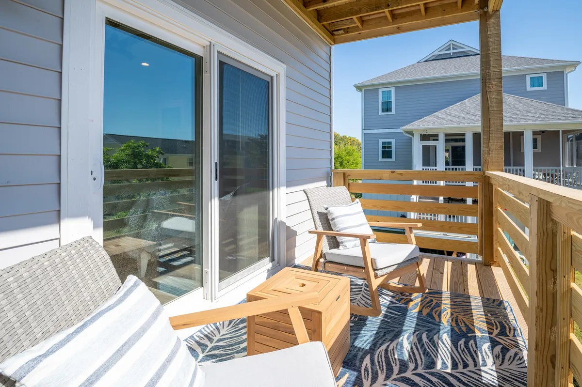 This image features an inviting outdoor seating area complete with a decorative rug and comfortable chairs, offering a view of the surrounding area. The ambiance is cozy and perfect for gatherings, while the open-air setting alludes to the promise of stunning sunrises and starry evenings.