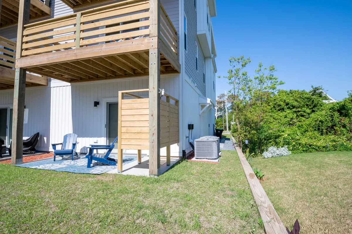 A peaceful wooden deck outfitted with comfortable outdoor seating and surrounded by a landscaped garden, the image evokes a sense of relaxation and the opportunity to enjoy the island's mild climate. The deck is a natural space for gathering before or after excursions.